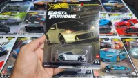 Hot Wheels Fast & Furious toy car packaging held by a hand with more packages in the background.